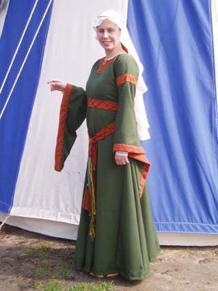Example of a Bliaut, made of green and orange wool. The lady also wears a veil and circlet